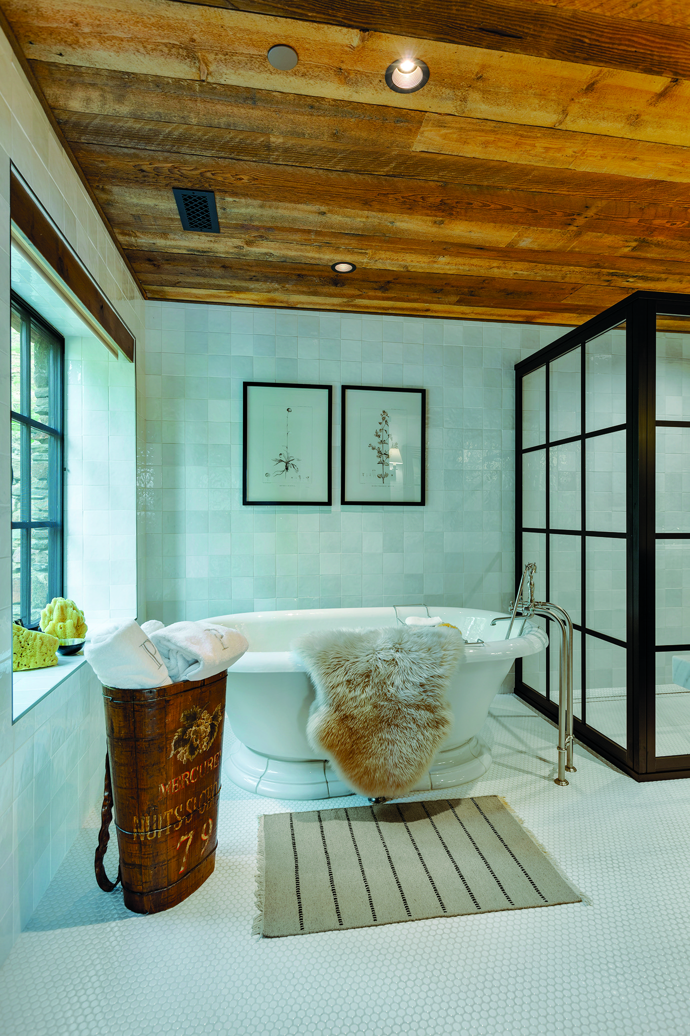 The vintage tub in the primary bathroom was repurposed from the old cabin before it was demolished. |