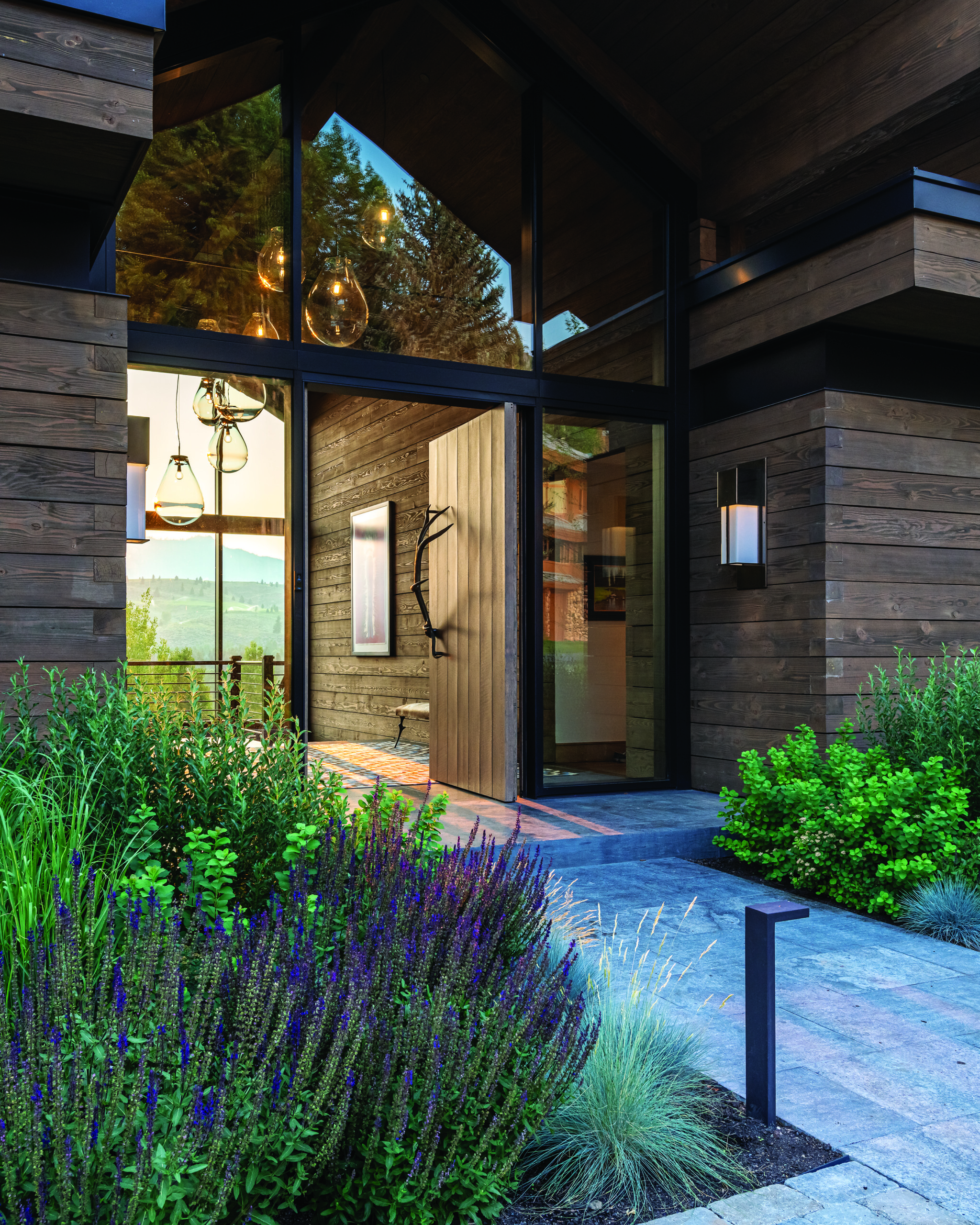 Perennials like salvia, echinacea and catmint as well asa contemporary chandelier highlight the entry. | Photo: Audrey Hall
