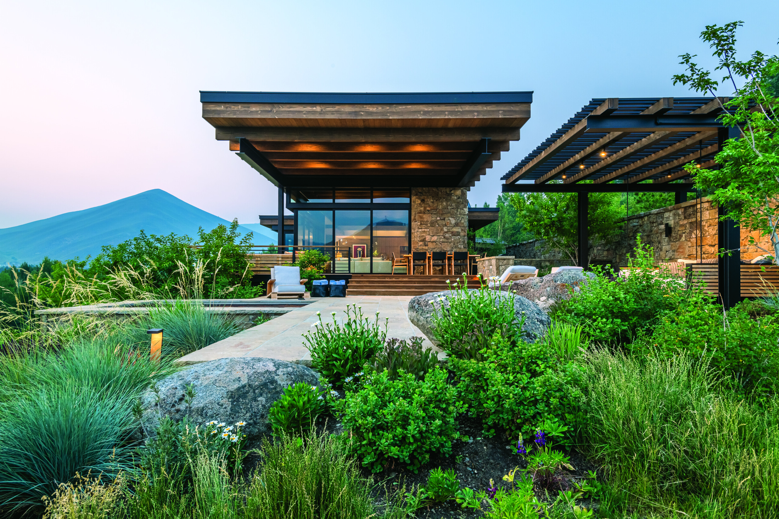 Thanks to impeccable architectural elements—including a large overhang and doors that fold all the way back—a lush landscape, exceptional views and an abundance of stylish furnishings, this home affords its owners the ultimate indoor-outdoor living experience. | Photo: Audrey Hall