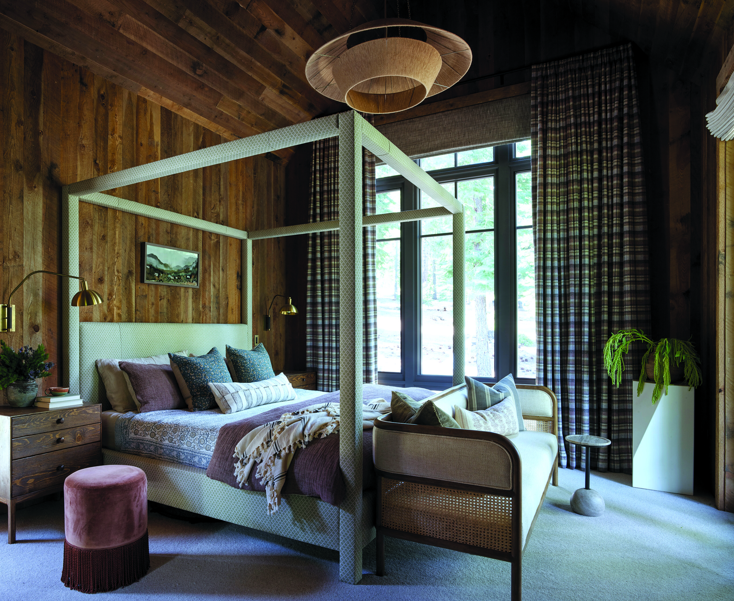 A canopy bed by Jayson Home is the centerpiece of the guest room. Side tables are by Shoppe Amber Interiors, the wall sconces are by Allied Maker, and the Tremaine sofa isby Four Hands. | Photo: