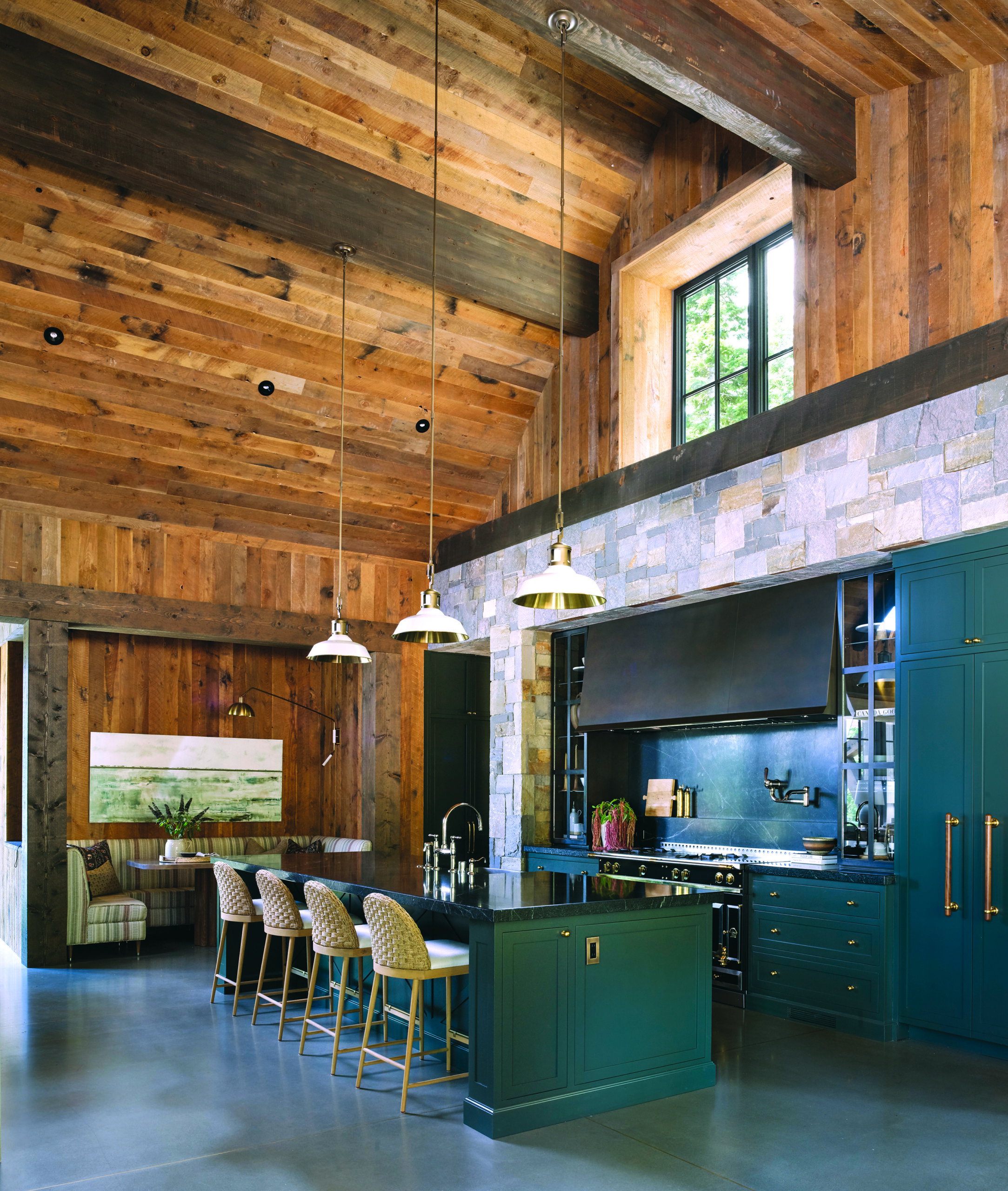Cabinets by S&S Millworks painted in Farrow & Ball Studio Green offer a direct link to the landscape. The counters and backsplash are fashioned from honed soapstone slabs, and the counter stools are by McGee & Co. | Photo: Paul Dyer