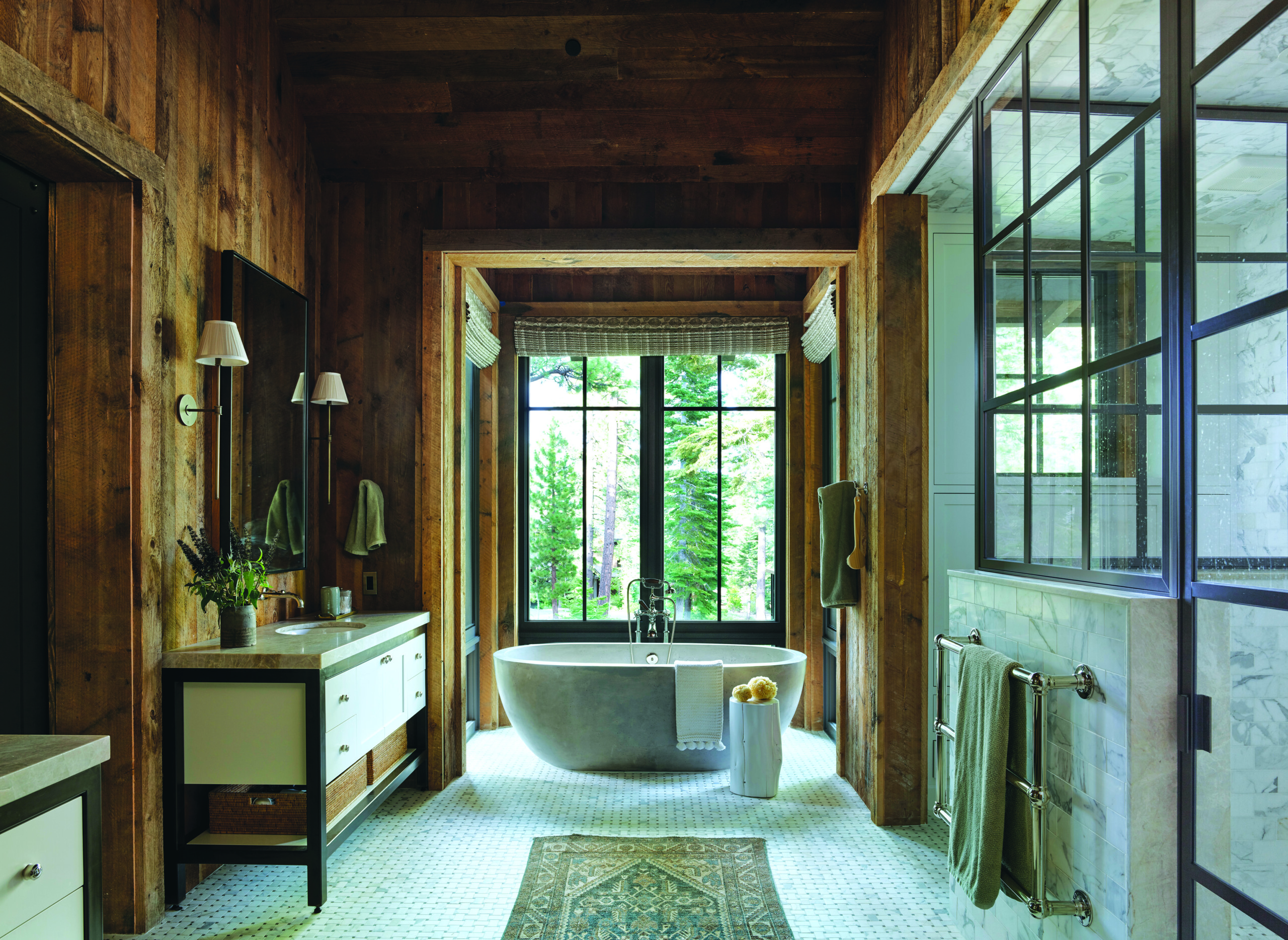 Calacatta basketweave mosaic tiles by AKDO and a custom vanity paintedin Benjamin Moore White Dove lighten and brighten the primary bathroom. Users of the soaking tub by Native Trails feel as if they are bathing outdoors. | Photo: Paul Dyer